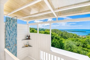 A balcony with a view of a lush landscape and the sea. - Vistas 360 Yellow - 3 Bedroom Home W/ Ocean Views (Politilly Bight)