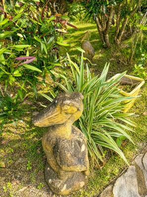 A garden statue of a bird with a yellow beak and a green plant beside it. - Vistas 360 Yellow - 3 Bedroom Home W/ Ocean Views (Politilly Bight)