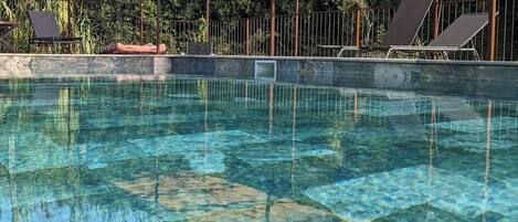 Una piscina al aire libre, una piscina climatizada