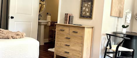 Escritorio, tabla de planchar con plancha y ropa de cama