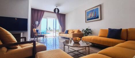 A modern living room with two sofas, a coffee table, and a TV.