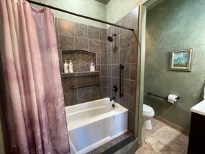 A bathroom with a bathtub, shower, and toilet.