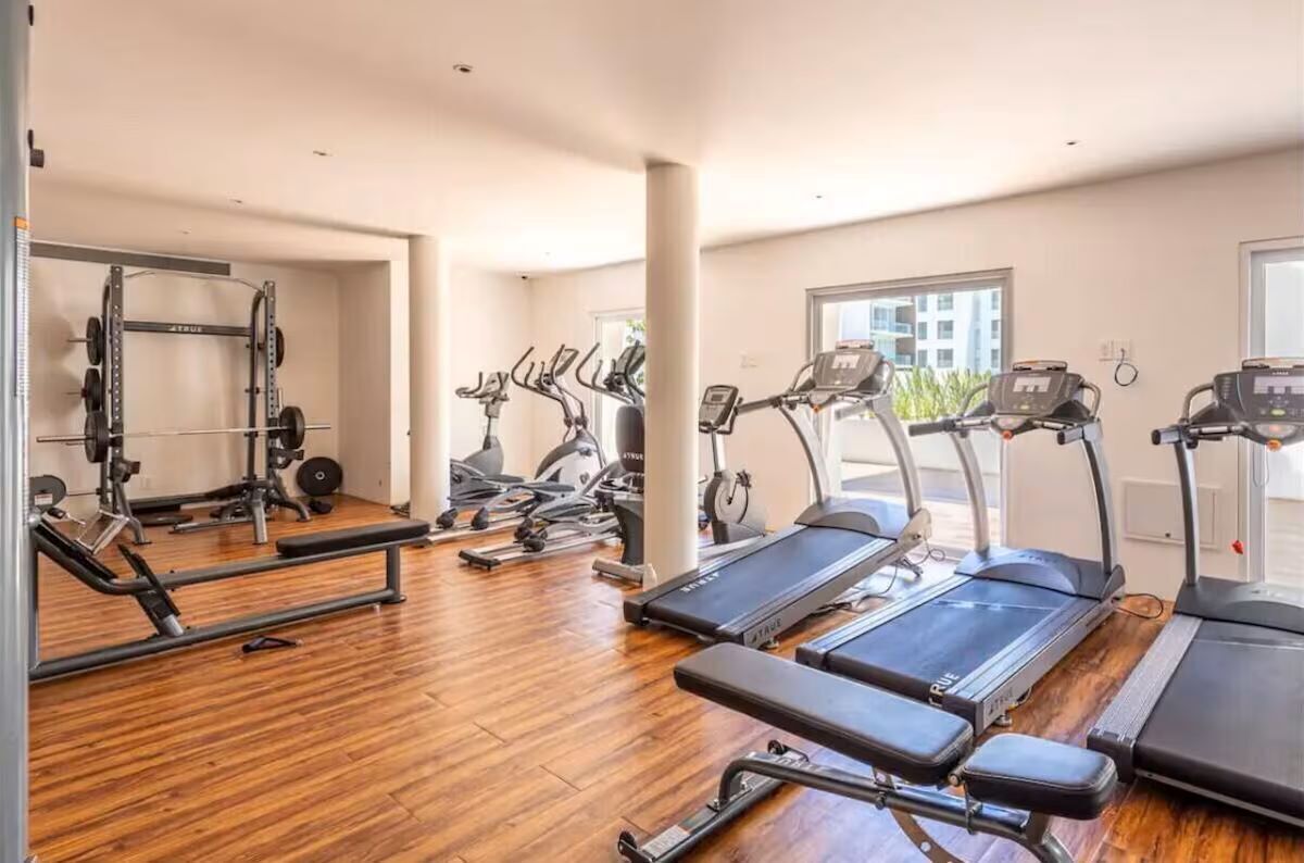 A gym with treadmills, elliptical machines, and weightlifting equipment.