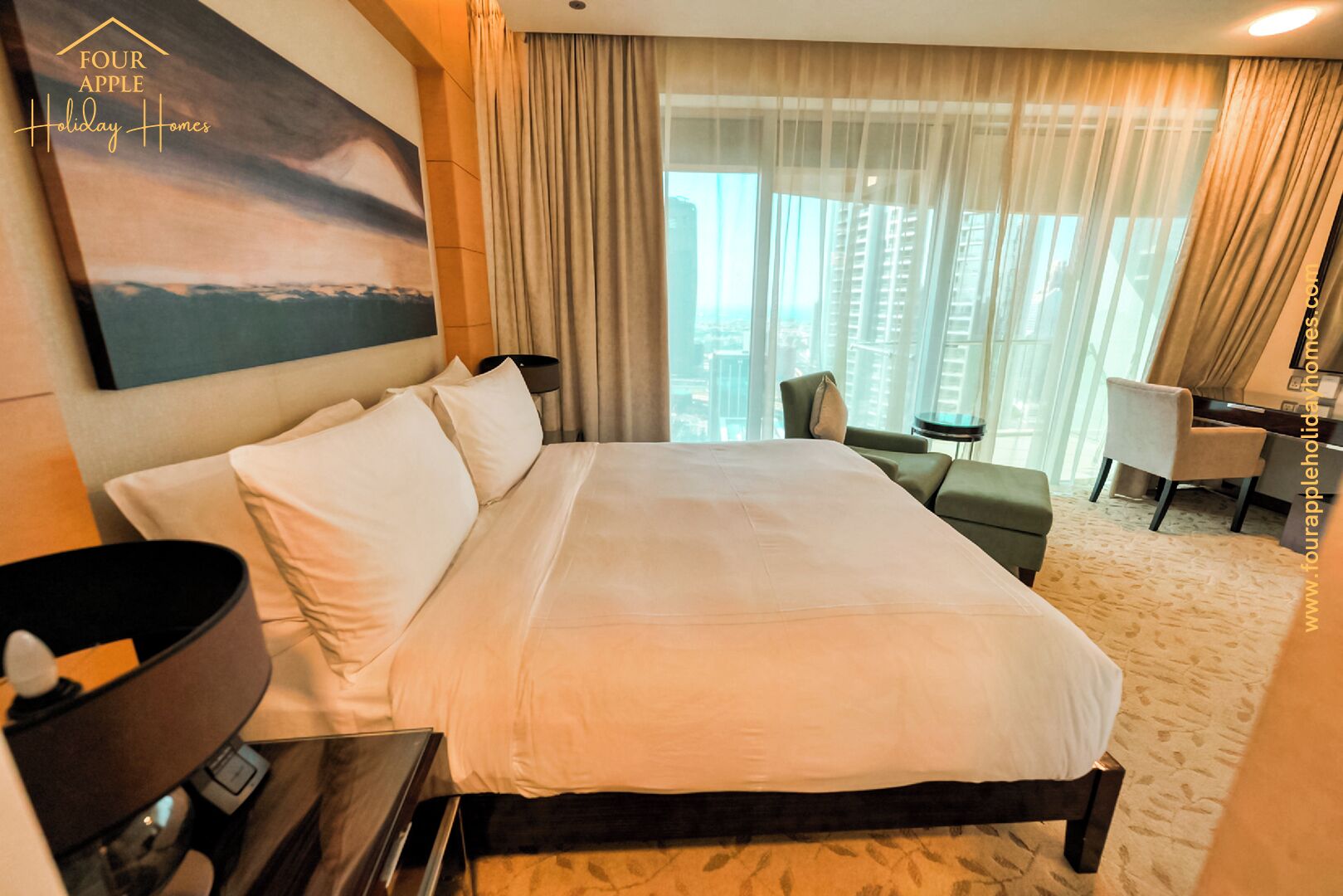 Habitación de hotel con una cama grande, un escritorio, una silla y vistas a la ciudad a través de amplios ventanales.