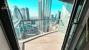 Un balcon offrant une vue sur la ville, avec en particulier des immeubles modernes de grande hauteur.