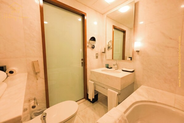 A bathroom with a toilet, sink, and bathtub.