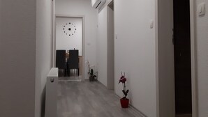 A hallway with a wooden floor, white walls, and a ceiling with recessed lighting. There is a door on the right and a small potted plant on the left. - Charming 2-bedroom apartment 2 with WiFi, AC in delightful Plitvice Lakes (Plitvice lakes)