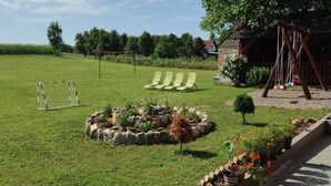 A grassy field with a goalpost, swings, and a small garden area. - Charming 2-bedroom apartment 2 with WiFi, AC in delightful Plitvice Lakes (Plitvice lakes)