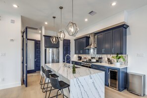 A modern kitchen with dark cabinets, a marble island, and stainless steel appliances. - Lux 4 Bed -Garage - City Views -12 Min Walk Downtown (Houston)