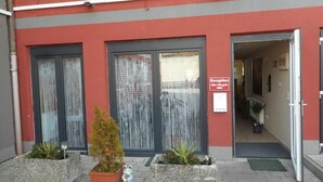 A building with a reception area, large windows, and potted plants. - Pension Alis (Augsburg)