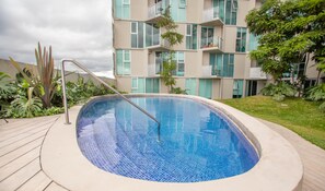 A swimming pool with a tiled edge, surrounded by a wooden deck. - Secrt Sabana 1BR · High Floor · Workspace + WiFi · Parking · Apt 2006 (Mata Redonda)