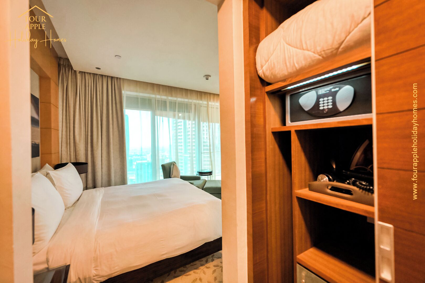 A hotel room with a bed, a wooden wardrobe, and a view of the city.
