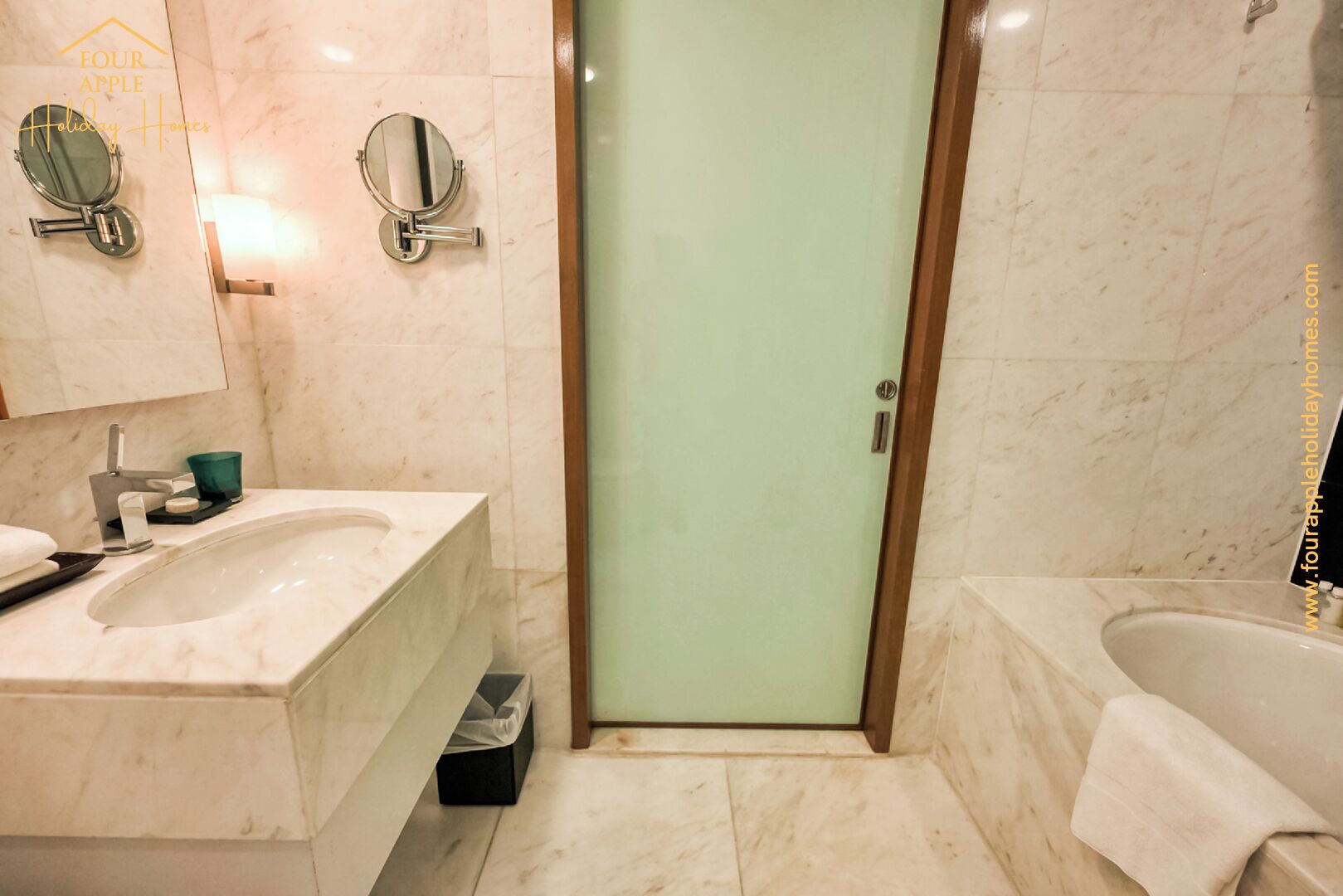 A bathroom with a marble sink, a bathtub, and two wall-mounted mirrors.