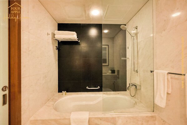 A modern bathroom with a glass-enclosed shower, a bathtub, and a towel rack.