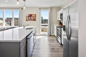 Enjoy cooking in this kitchen with a large island, sink, and stainless steel appliances.