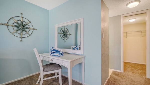A bathroom with a white vanity, a mirror, and a wall-mounted compass decoration.