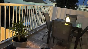 Kattoterassi, jossa on aurinkotuoli, ruokapöytä tuoleineen ja ruukussa oleva kasvi.