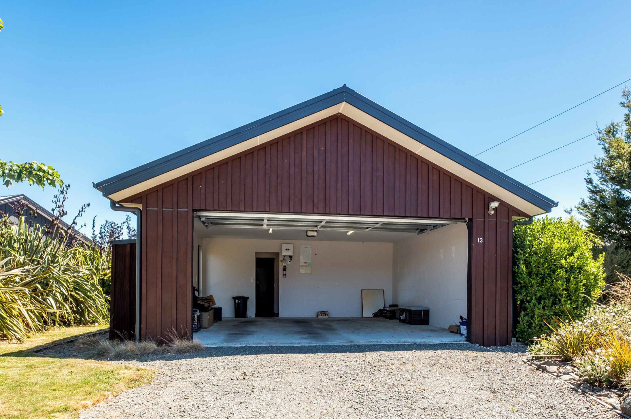 A single-story building with a brown exterior and a garage door open.