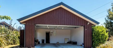 A single-story building with a brown exterior and a garage door open.