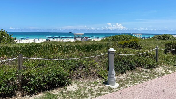 A beach view with a fenced area, a lifeguard tower, and a distant building labeled "CONVENTION". - BeachFront On The Sand Unit #326 South of 5th, 335 Ocean Dr, Miami Beach (Miami Beach)