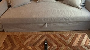 A light grey sofa with four cushions against a plain wall. - BeachFront On The Sand Unit #326 South of 5th, 335 Ocean Dr, Miami Beach (Miami Beach)