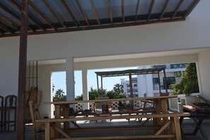 Enjoy dining or socializing in this outdoor patio area with tables and chairs, offering a view of the surrounding complex.