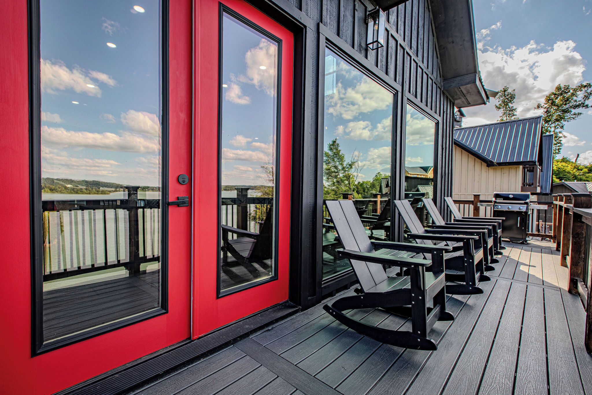 A deck with outdoor seating and a red door.