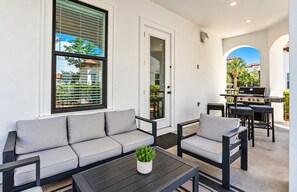 An outdoor seating area with a sofa, chairs, and a table.