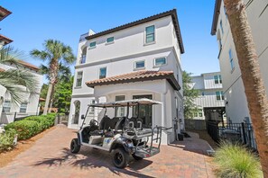 A two-story building with a paved driveway and a golf cart parked in front. - Heated Private Pool*6-Seater Golf Cart*Steps2Beach (Santa Rosa Beach)