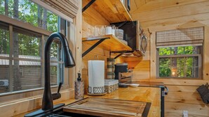 Una cocina moderna con un grifo negro, encimeras de madera y un horno integrado.