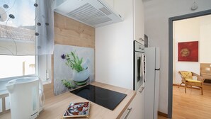 Una cocina moderna con estufa integrada, tetera y una planta decorativa.