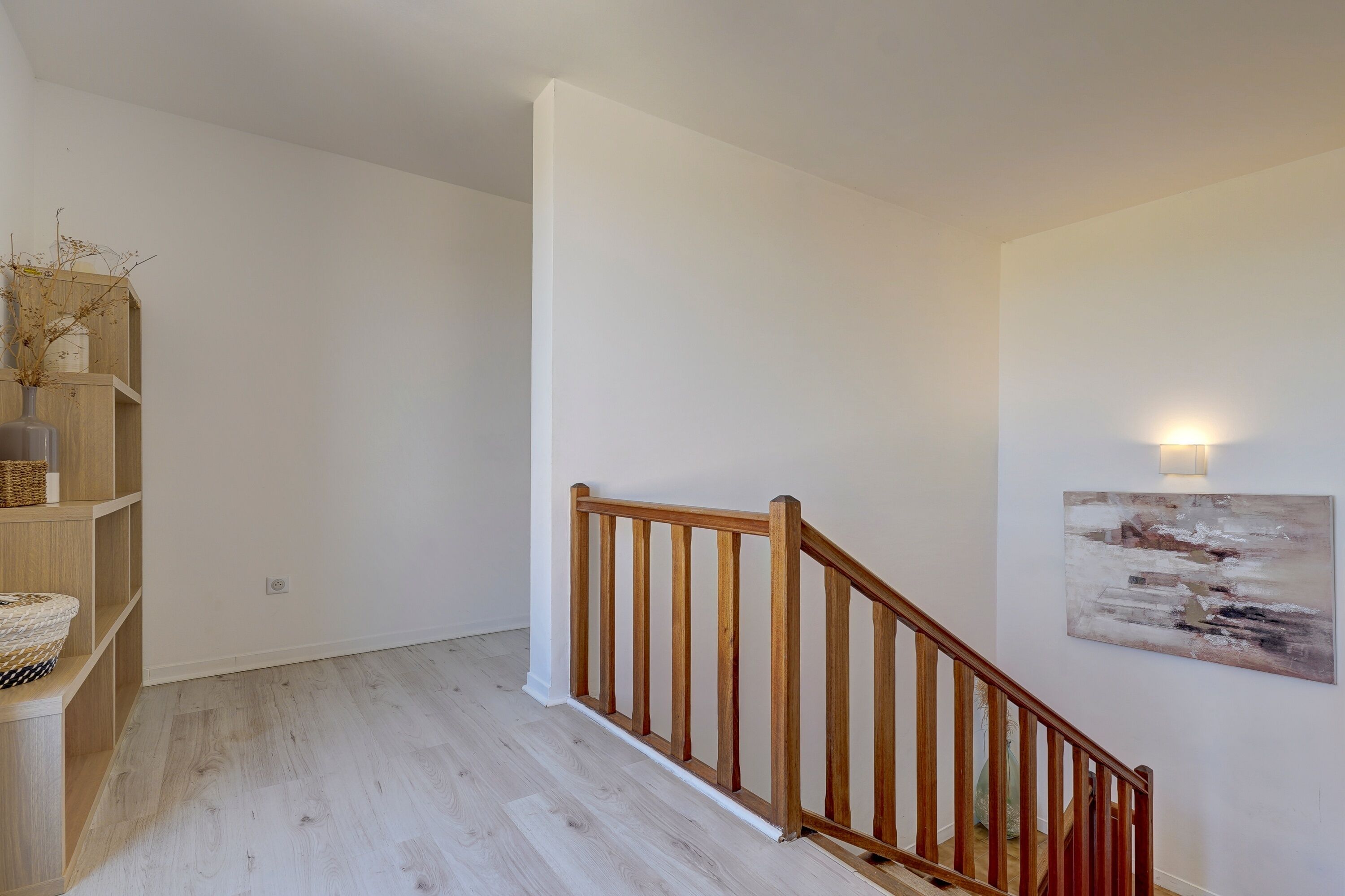 Un escalier avec des rampes en bois menant à un palier.