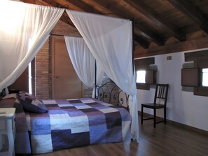 A bedroom with a bed, a chair, a window, and a door.