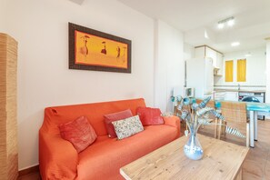 Una sala de estar moderna con un sofá, una mesa de centro de madera y un cuadro en la pared.