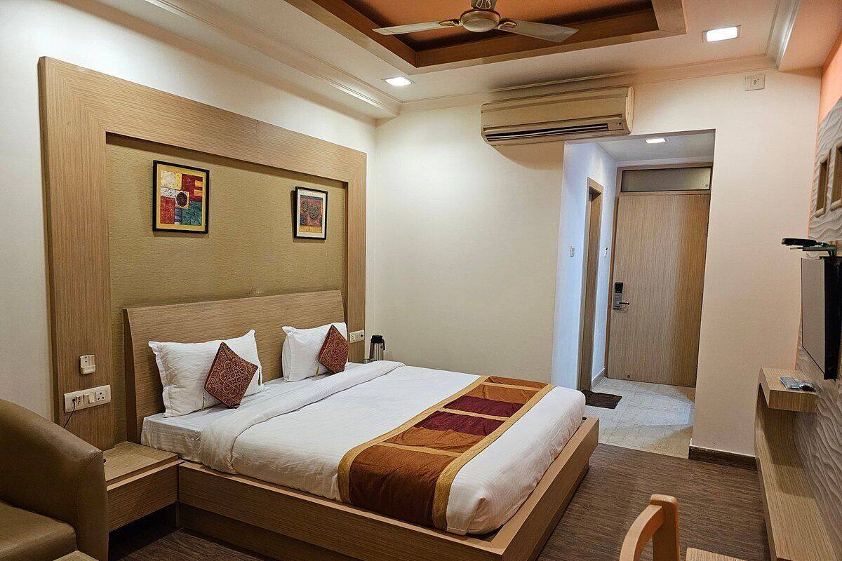 A hotel room with a wooden bed, a desk, and a chair.