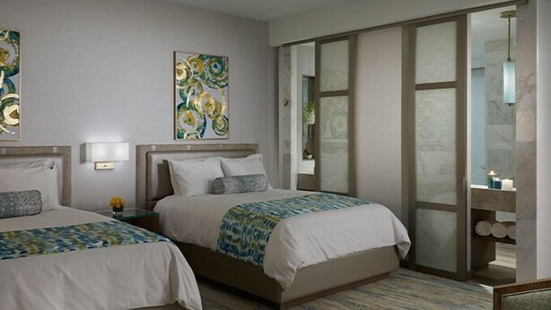 A hotel room with two beds, a large window, and artwork on the walls. - Capital Plaza Residency (Mannarkkad)