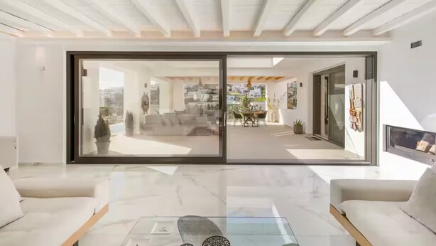 A modern living room with a glass sliding door leading to an outdoor patio.