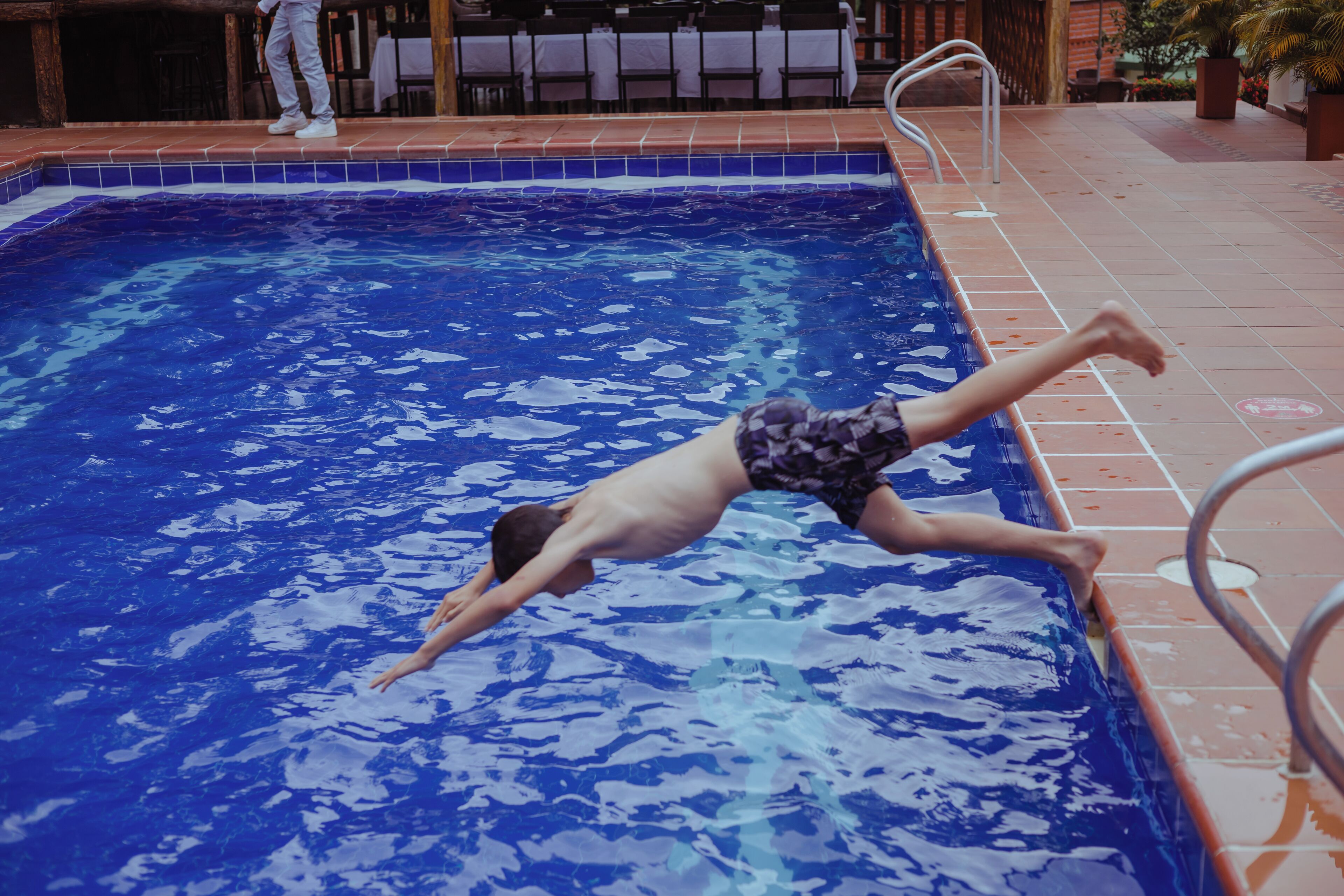 Ein Schwimmbecken mit gefliestem Rand und einer Metallhandstange.