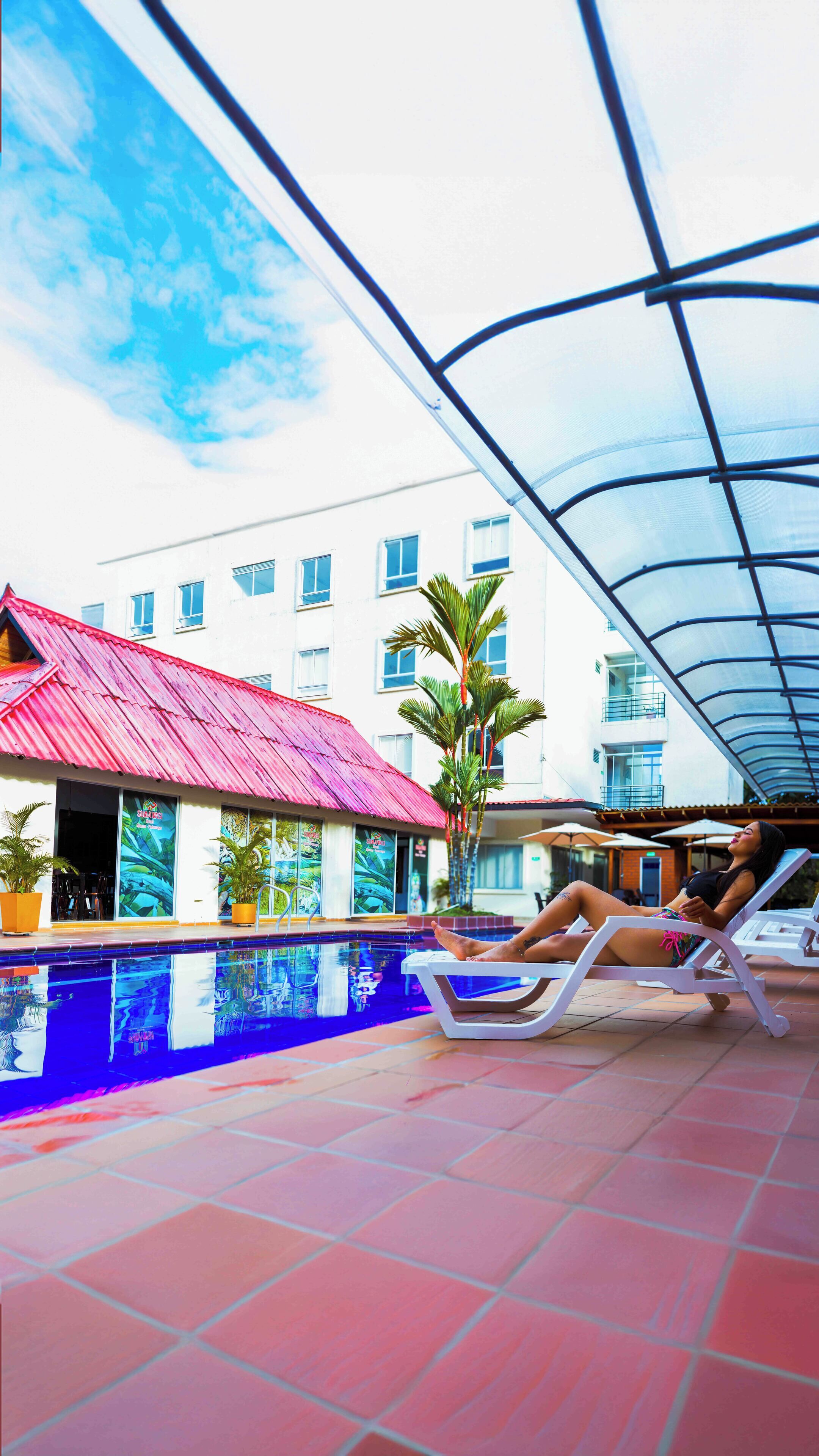 Una piscina al aire libre, sombrillas. HOTEL SUMAWASI