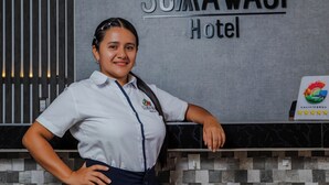 A reception area with a sign for Sumawasi Hotel, a logo, and a rating badge. - HOTEL SUMAWASI (Mocoa)