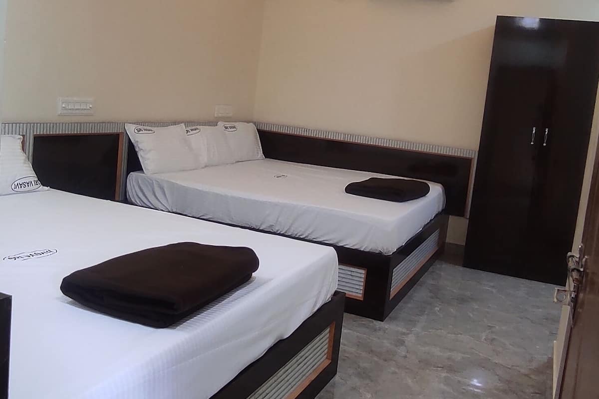 A hotel room with two beds, a ceiling fan, recessed lighting, a marble floor, and a wardrobe.