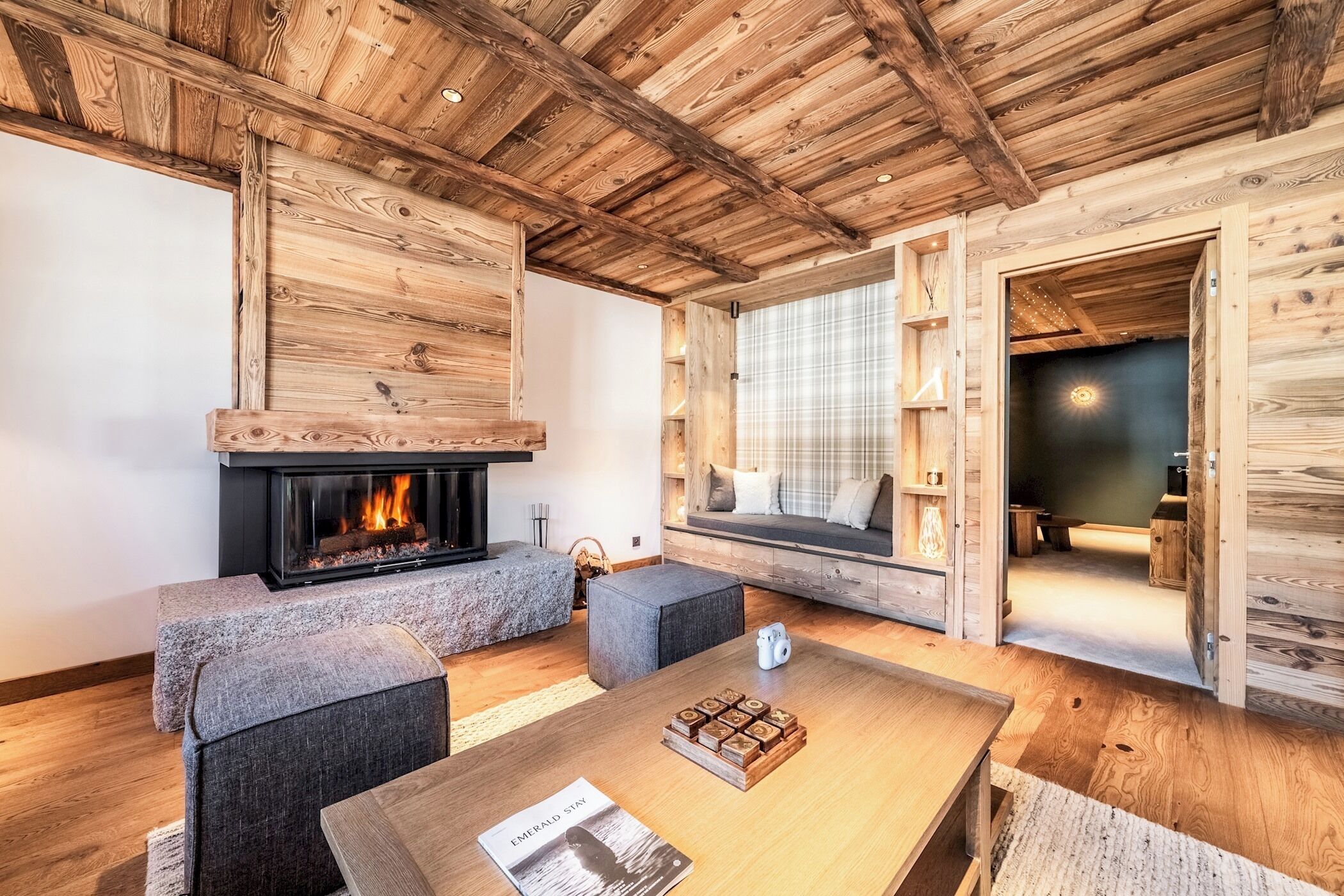 Ein gemütliches Blockhaus-Interieur mit Kamin, Sitzecke und Holzwänden.