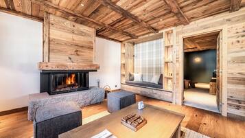 Ein gemütliches Blockhaus-Interieur mit Kamin, Sitzecke und Holzwänden.