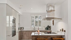 Une cuisine moderne dotée d’un îlot central, de touches de bois et d’une grande fenêtre.