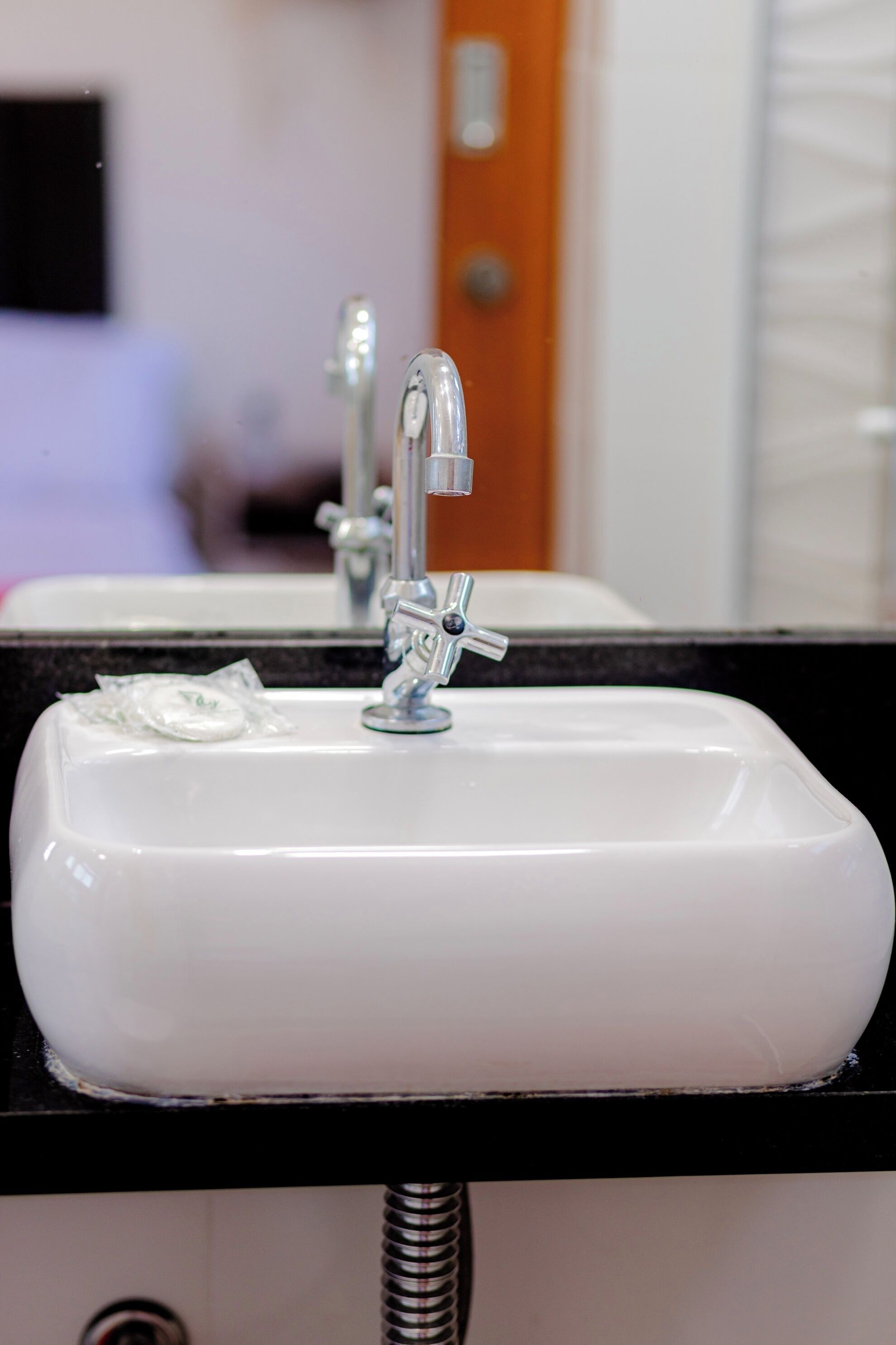 A bathroom sink with a chrome faucet and a soap dispenser.