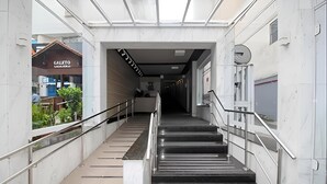 Una escalera interior moderna con barandillas de metal y techo de cristal.