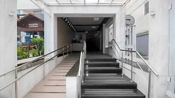 A modern indoor staircase with metal railings and a glass ceiling.