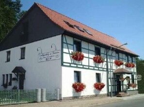 A traditional building with a white facade, dark roof, and multiple windows. - Gästehaus Zum Felsenkeller Steigerthal  (Nordhausen)