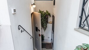 A narrow staircase with a metal handrail, a door at the top, and a potted plant at the bottom. - Room 'Pretty Suite Firenze' with Private Garden, Wi-Fi and Air Conditioning (Fiesole)