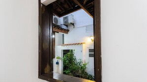 A mirror reflecting an air conditioning unit, a door, and a wall with a light fixture. - SUH Catete 06 Big House Metro (Rio de Janeiro)